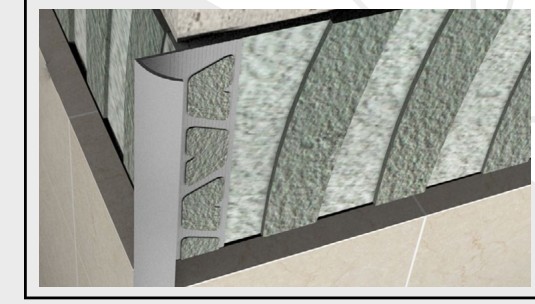 Cornière PVC posée en angle extérieur sur revêtement carrelage.