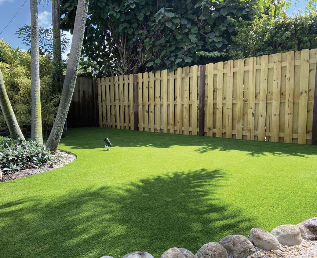 Jardin résidentiel avec terrasse, salon de jardin et gazon synthétique doux au toucher.