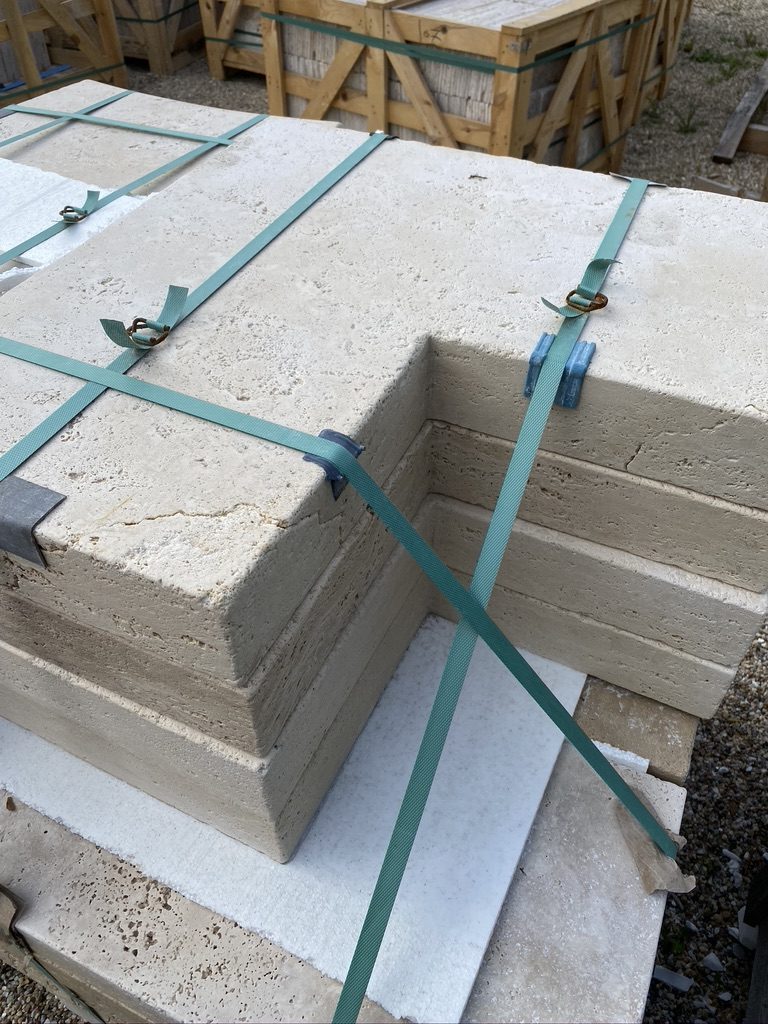 Pièces de margelle d'angle en travertin, sanglées, prêtes à l'expédition.